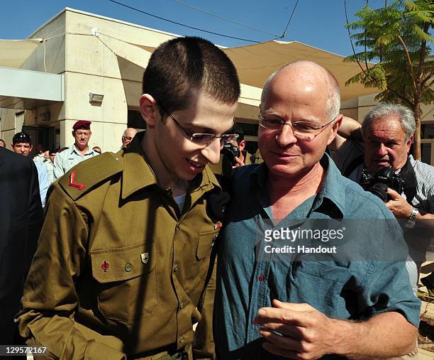 In this handout photo provided by the Israeli Defence Force, freed Israeli soldier Gilad Shalit walks with his father Naom Shalit at Tel Nof Airbase...