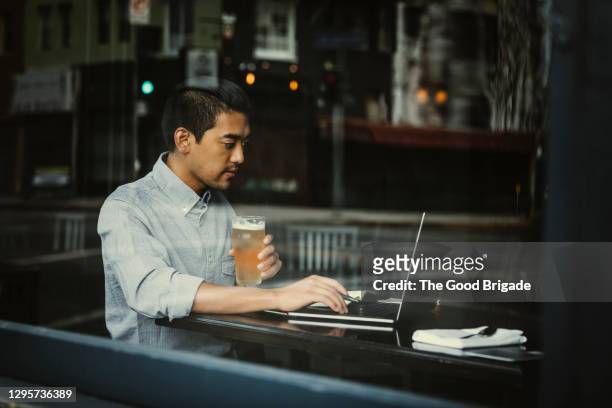 Young man working on laptop in pub
