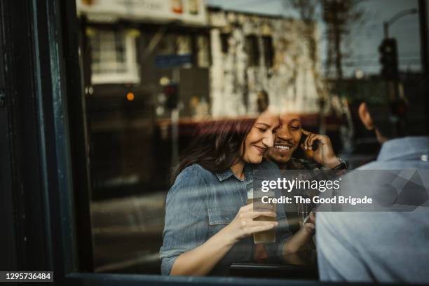 friends enjoying drinks in bar during happy hour - view-through-restaurant-window stock pictures, royalty-free photos & images