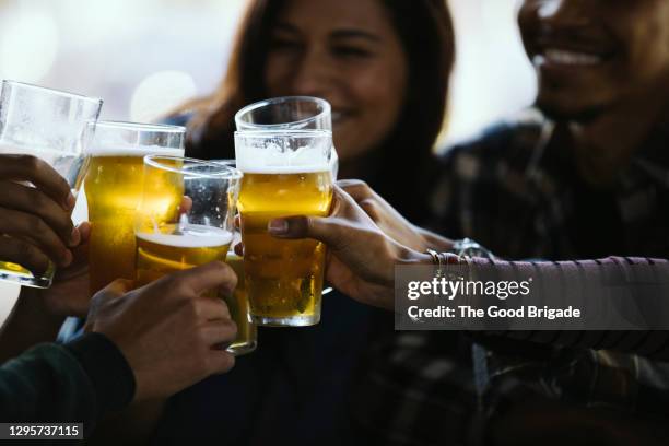 close-up of happy friends toasting beer glasses in pub - lageröl bildbanksfoton och bilder