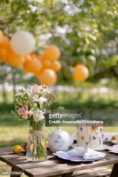 a bouquet and cake on the table outdoors - happy birthday flowers images stock pictures, royalty-free photos & images