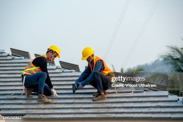 roofer worker installing new roof. - roofer stock pictures, royalty-free photos & images