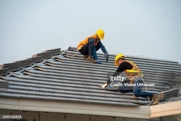 roofer worker installing new roof. - hail stock-fotos und bilder