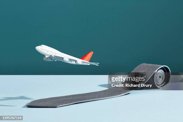 an aeroplane taking off on a runway made from a business tie - toy airplane stock-fotos und bilder