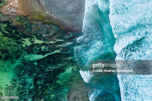 big ocean waves hitting a coral reef. view from above. - indonesia aerial stock pictures, royalty-free photos & images