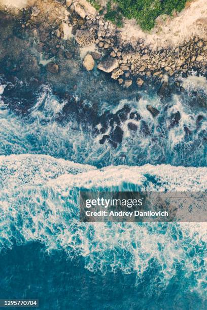 ocean waves hitting a rocky beach. view from above. - underwater cliff stock pictures, royalty-free photos & images
