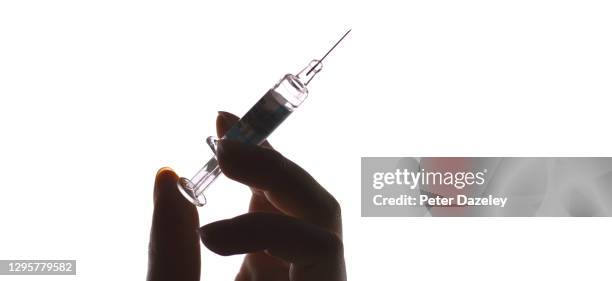 hand holding syringe, in silhouette - diphtheria stock pictures, royalty-free photos & images