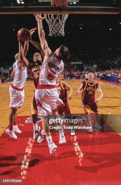 Craig Johnson, Guard for the Santa Clara University Broncos drives to the basket as Gerrit Terdenge of the Fresno State Bulldogs attempts to block...