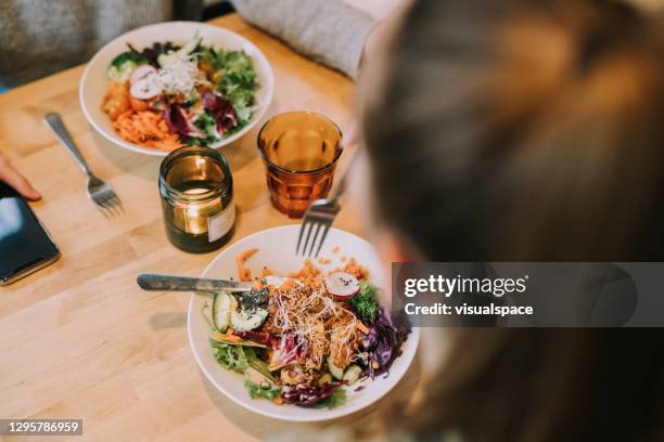 teenager influencers trying food at vegan cafe - pokes stock pictures, royalty-free photos & images