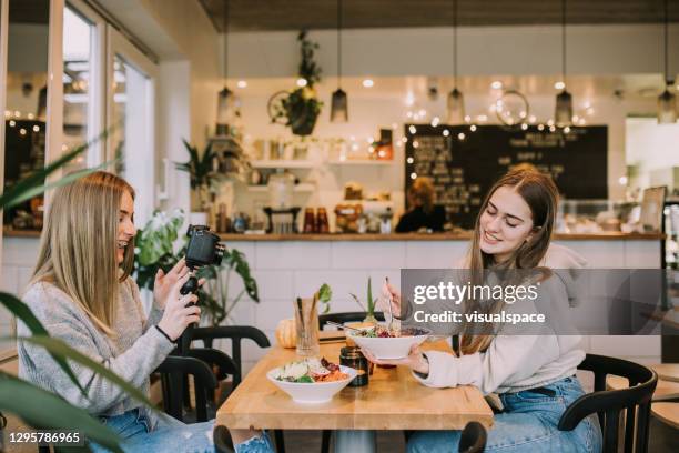 teenager influencers making a video at vegan cafe - teen doing filming imagens e fotografias de stock