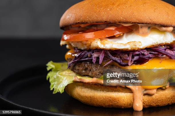 hamburguesa de queso con tocino sobre fondo negro oscuro - bocadillo de beicon lechuga y tomate fotografías e imágenes de stock