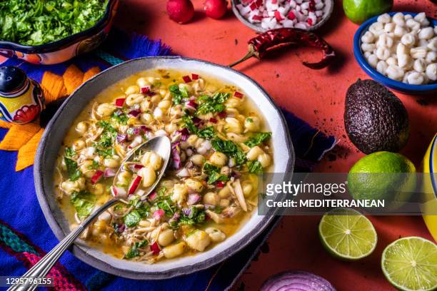 pozole mexican corn stew with meat, mote corn, radishes, coriander, lime and lettuce - chicken stew stock pictures, royalty-free photos & images