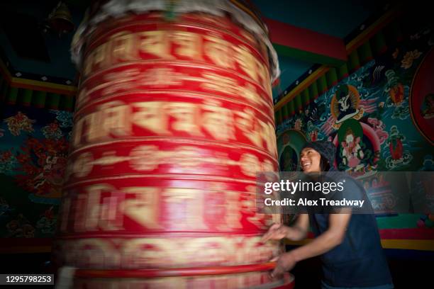a nepali man spins a prayer wheel in tengboche monastery in the everest region of nepal - khumbu stockfoto's en -beelden