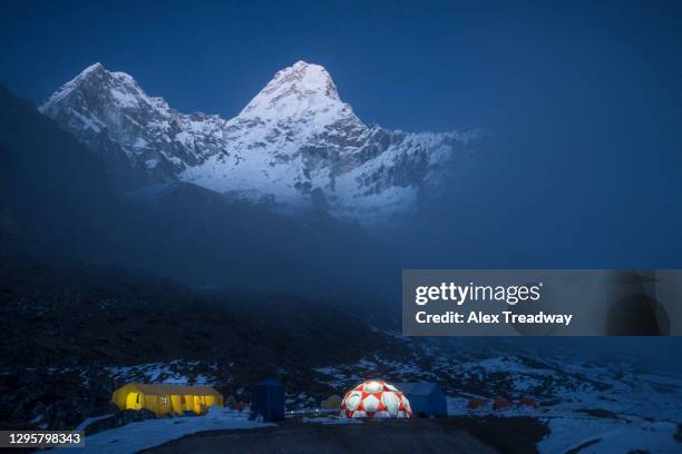 ama dablam base camp in the everest region of nepal glows with the peak of ama dablam also visible in the moonlight - base camp stockfoto's en -beelden