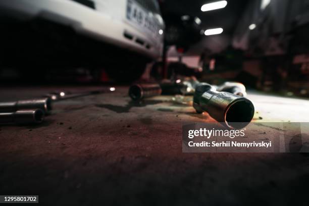 heads and socket wrench, tool scattered on the floor. vehicle in the background. car service. selective focus. - ball on a table stockfoto's en -beelden