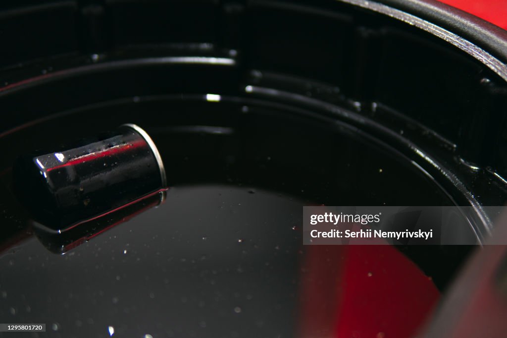 Container for draining used oil. Oil filter and plastic bowl. Automotive service and maintenance concept. Close up, selective focus. Copy space