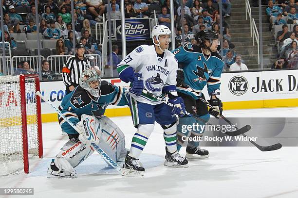 Goaltender Thomas Greiss and defenseman Douglas Murray of the San Jose Sharks defend the net against center Manny Malhotra of the Vancouver Canucks...