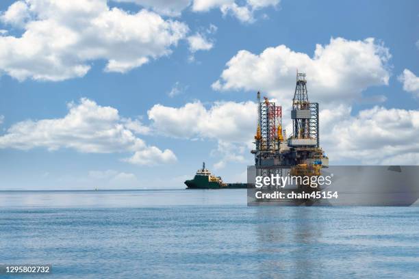 the oil and gas drilling rig at platform for drilling and producing crude oil, natural gas and water in offshore or gulf, petroleum field. industry concept of oil petroleum industry. - boortoren stockfoto's en -beelden