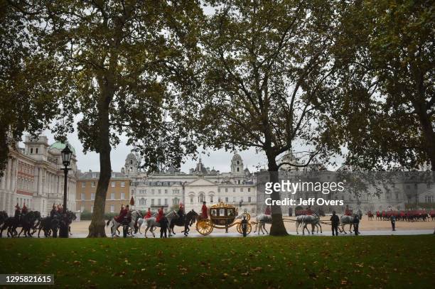 State Opening of Parliament. The carriage of Queen Elizabeth II passes Horse Guards Parade, London, England, en-route to the Palace of Westminster...