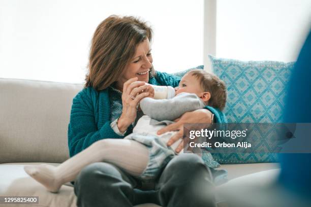 grandmother feeding baby - mexican and white baby stock pictures, royalty-free photos & images