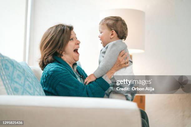 grandmother feeding baby - mexican and white baby stock pictures, royalty-free photos & images