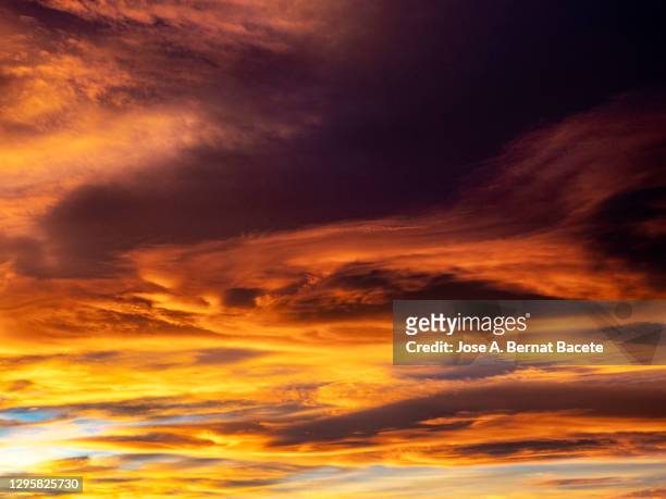 full frame of the sky with high colored clouds at sunset a windy day. - grey clouds stock pictures, royalty-free photos & images