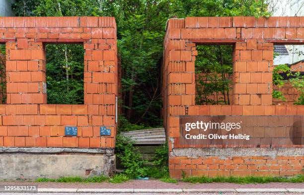 the remains of an unfinished house construction. consisting only of the foundation walls. trees are already growing inside. - collapsing wall stock pictures, royalty-free photos & images