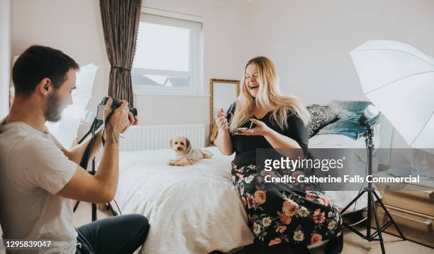 body positive social media icon performs in a small bedroom with her friend as a camera operator - plus size model male stock pictures, royalty-free photos & images