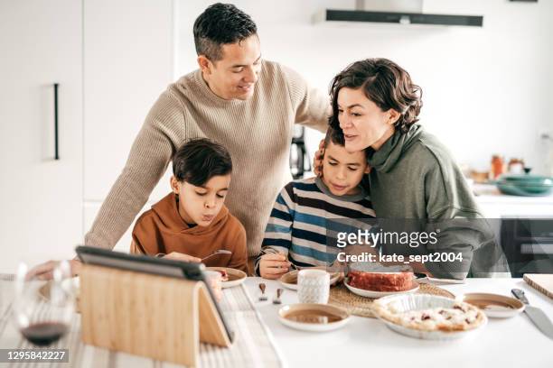 family in the kitchen with online friends - mid adult woman sweater stock pictures, royalty-free photos & images