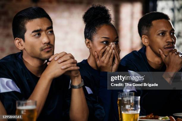 friends watching football game at bar - woman black shirt stock pictures, royalty-free photos & images