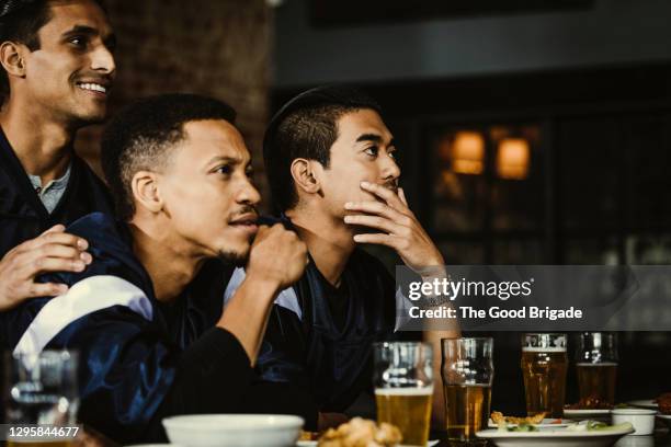 sports fans sitting at bar in pub drinking beer - american football game bildbanksfoton och bilder