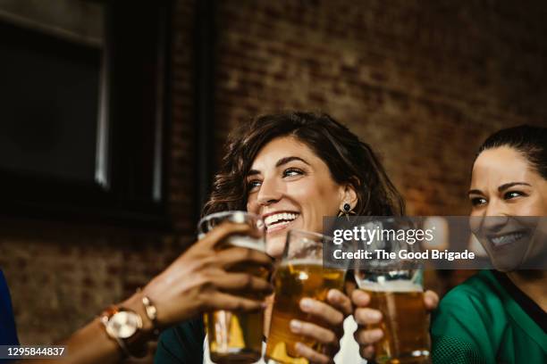 excited female sports fans celebrating in bar at pub - happy hour stockfoto's en -beelden