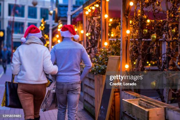 een gemengd raspaar dat van de warme koffiecultuur in een de winterbar geniet - christmas market decoration stockfoto's en -beelden