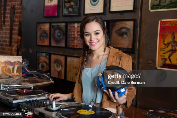 Actress Hayley Orrantia poses for a portrait at a record store with a record turn table on October 26, 2014 in Hollywood California.