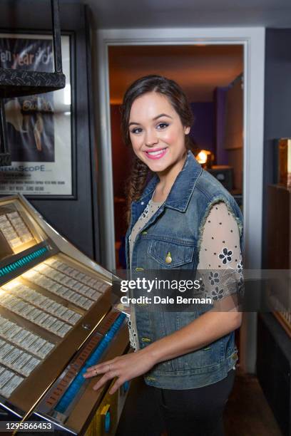 Actress Hayley Orrantia poses for a portrait with a juke box at a record store with a record turn table on October 26, 2014 in Hollywood California.