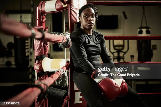 portrait of tired female boxer sitting in boxing ring - boxing womens stock pictures, royalty-free photos & images