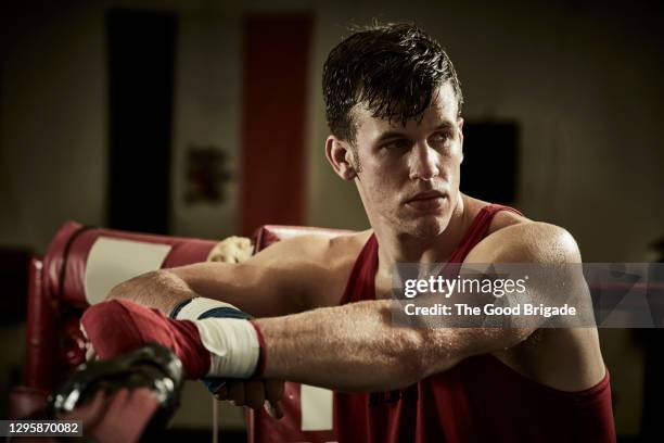 thoughtful male boxer standing in boxing ring at health club - boxing corner stock pictures, royalty-free photos & images