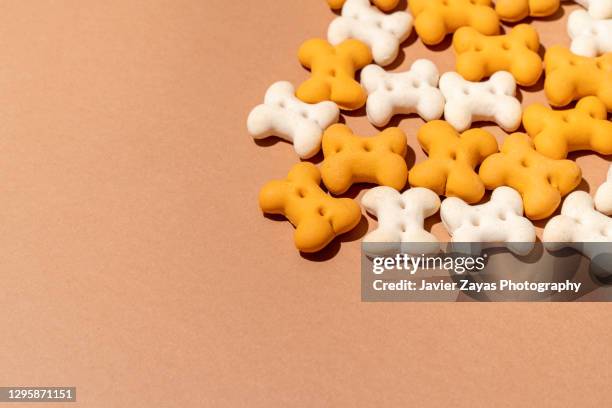 some bone shaped dog treats on brown background - dog white background stock pictures, royalty-free photos & images