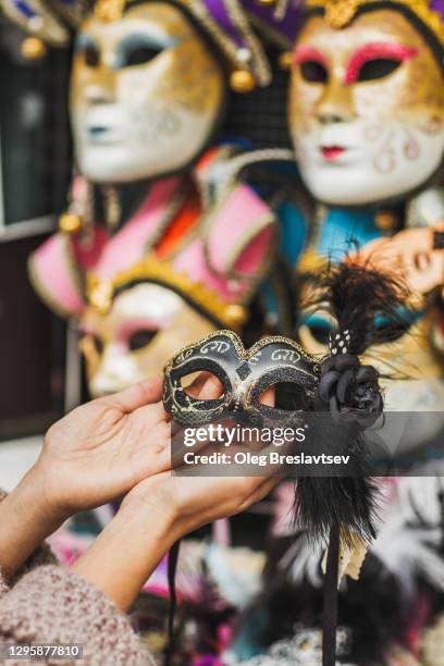 woman hands close-up holding venetian mask on italian market. traditional souvenir from venice - fiesta posterior 個照片及圖片檔