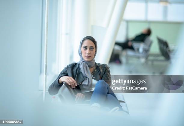 portrait of muslim woman sitting at the airport - lebanese ethnicity stock pictures, royalty-free photos & images