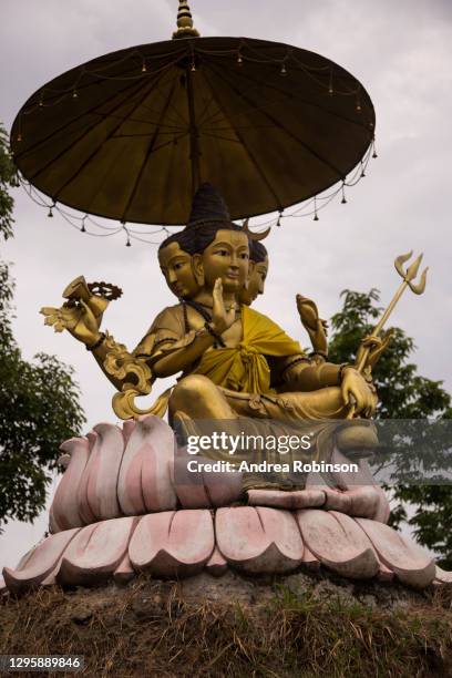 four faced golden statue of lord dattatreya sitting on a lotus flower at the jalapadevi hindu temple, dedicated to lord shiva at nagarkot in the kathmandu valley, nepal. - sitting shiva stock pictures, royalty-free photos & images