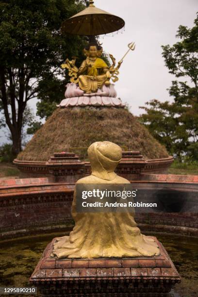 four faced golden statue of lord dattatreya sitting on a lotus flower at the jalapadevi hindu temple, dedicated to lord shiva at nagarkot in the kathmandu valley, nepal. - sitting shiva stock pictures, royalty-free photos & images