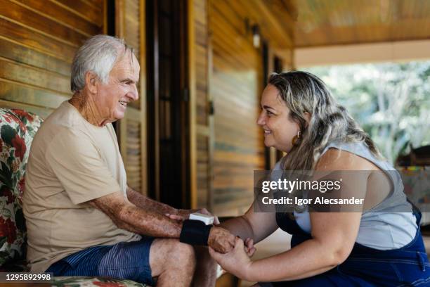 daughter checking father's pressure on the balcony - side dish stock pictures, royalty-free photos & images