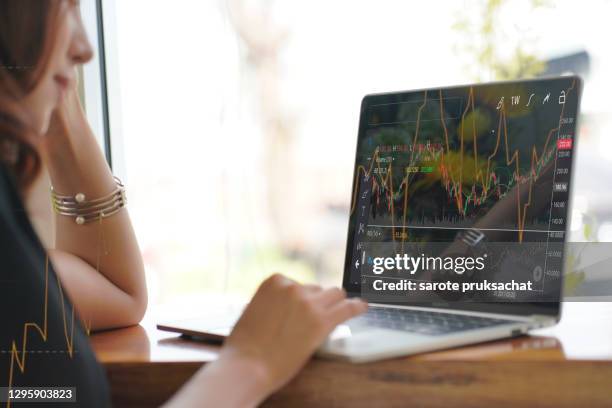 asian woman looking stock market graph at monitor screen . - data trust stock pictures, royalty-free photos & images
