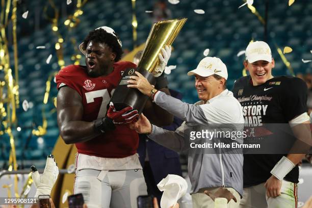Alex Leatherwood of the Alabama Crimson Tide holds the trophy alongside head coach Nick Saban following the College Football Playoff National...
