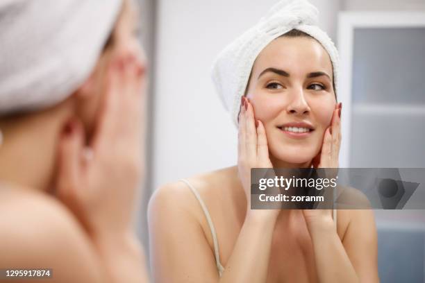 woman looking herself in mirror - cloth face mask stock pictures, royalty-free photos & images