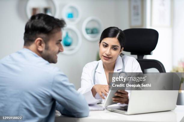 uses laptop while talking with patient stock photo - india stock pictures, royalty-free photos & images