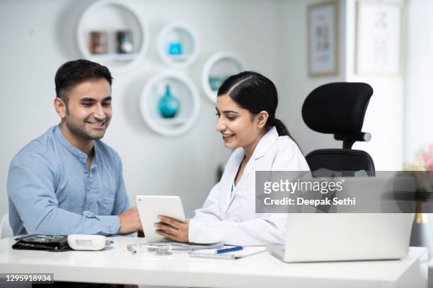 verwendet laptop im gespräch mit patienten stock foto - indian doctors stock-fotos und bilder