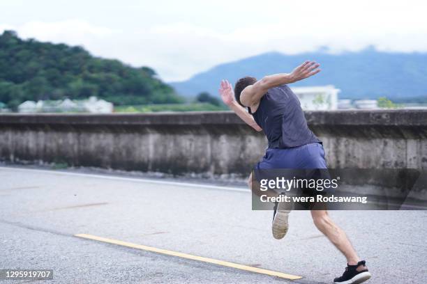 young man doing sprinting runs motions - laufwettbewerb der männer stock-fotos und bilder