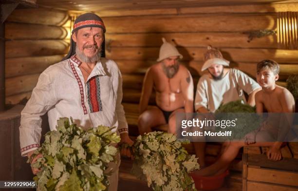 groep mannen nemen deel aan saunabehandelingen. russische gebruiken en tradities - banya stockfoto's en -beelden